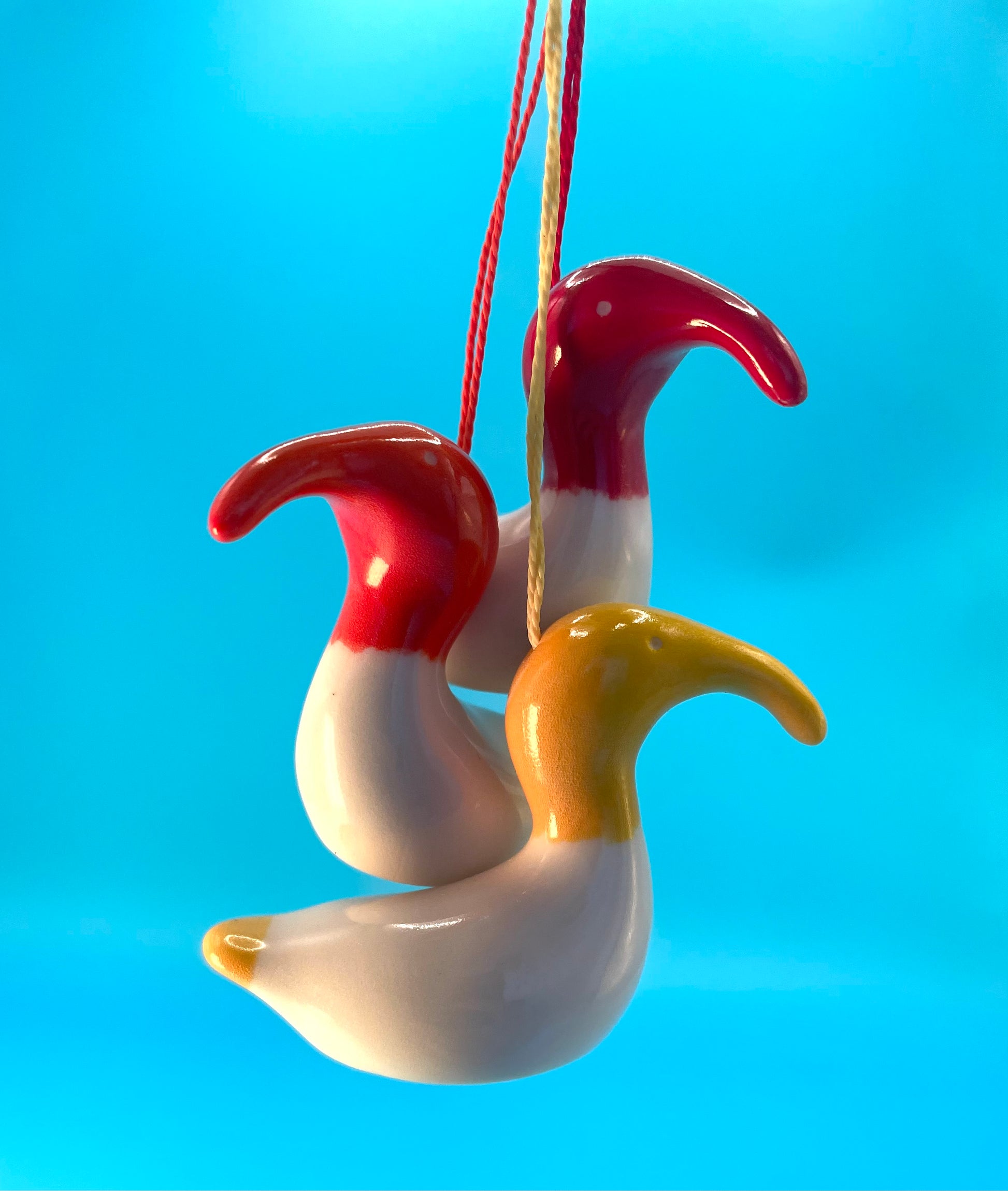 Three small ceramic decorations depicting an Australian White Ibis, also known as a Bin Chicken. Great for Easter or Christmas presents or decorations. Red, yellow and orange.