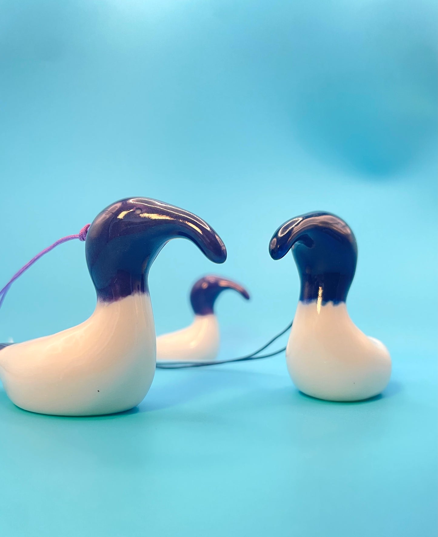 Handmade ceramic ornament of an Australian White Ibis. Bin Chicken. Purple and blue bin chickens having a dance off.