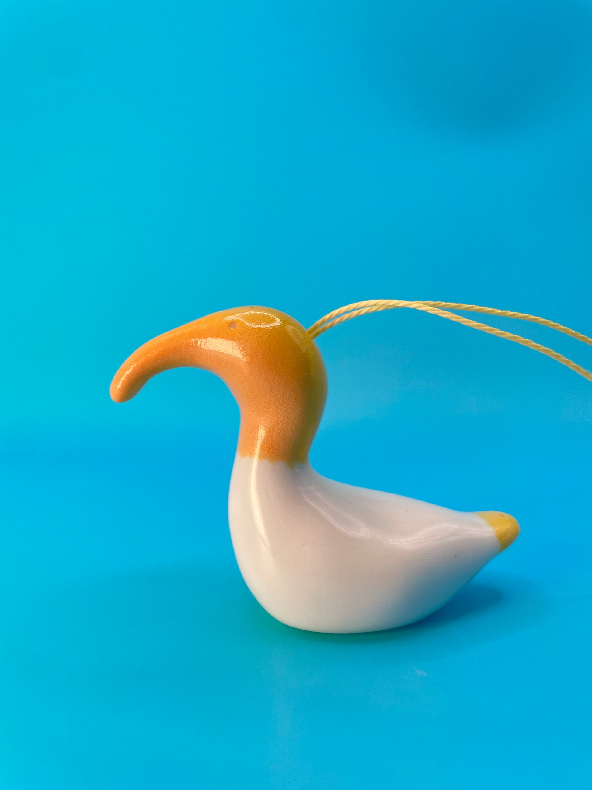 Vivid yellow ceramic representation of the Australian White Ibis, crafted with intricate details and a cheerful design.