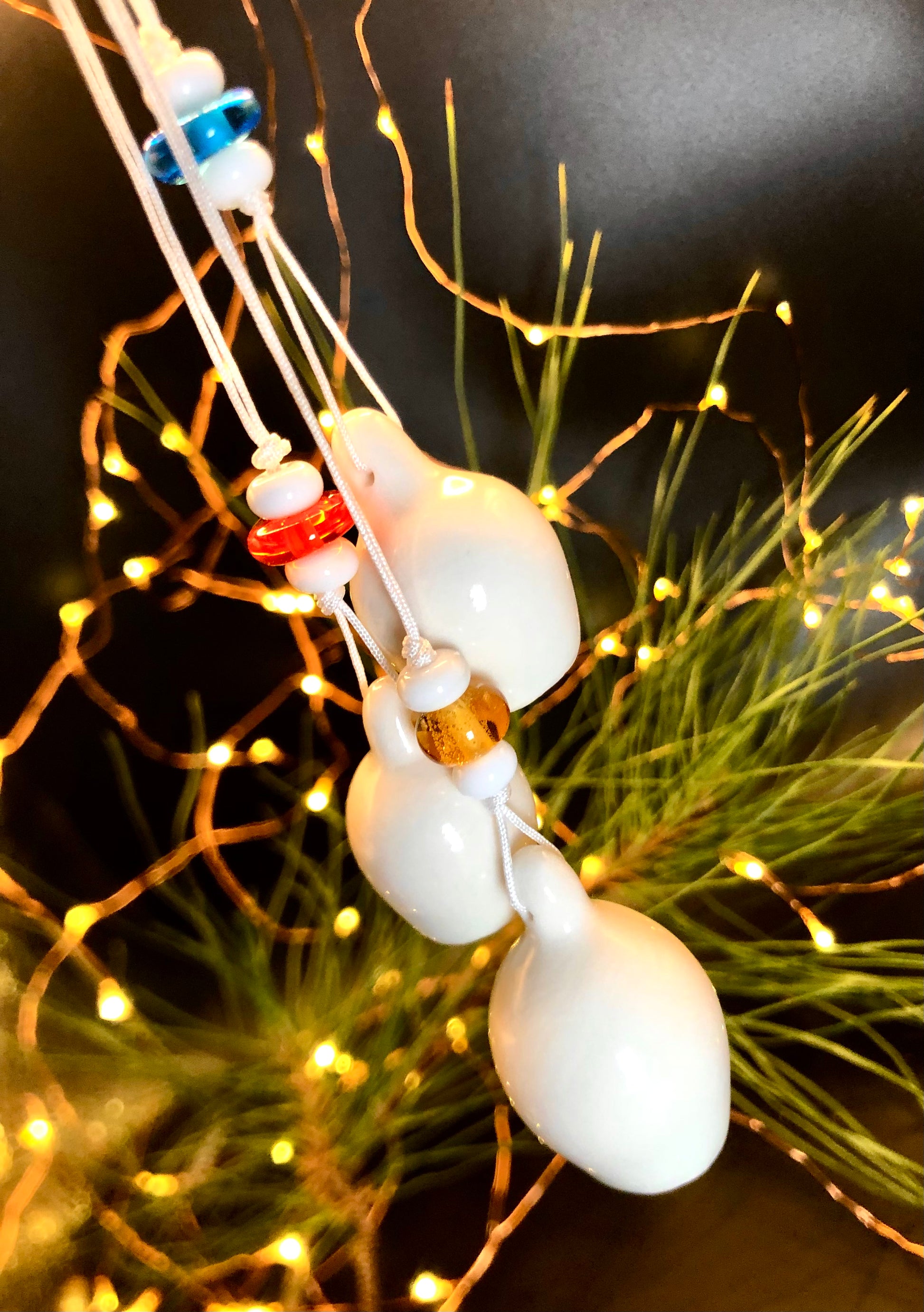 Christmas tree adorned with a string of three porcelain gumnuts, complemented by glass beads in a variety of colours—blue, red, yellow, and white—creating a whimsical and enchanting holiday display that celebrates Australian culture.
