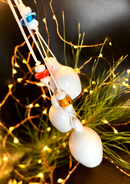 Christmas tree adorned with a string of three porcelain gumnuts, complemented by glass beads in a variety of colours—blue, red, yellow, and white—creating a whimsical and enchanting holiday display that celebrates Australian culture.