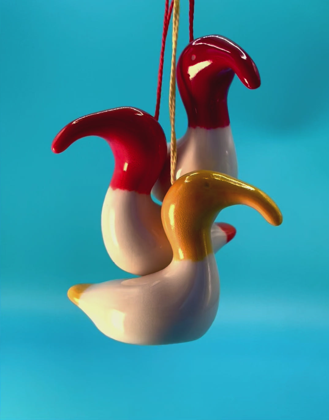 Colourful animation of three Australian White Ibises, or 'bin chickens,' with red and yellow decorations hanging from them, capturing their lively and playful personalities.